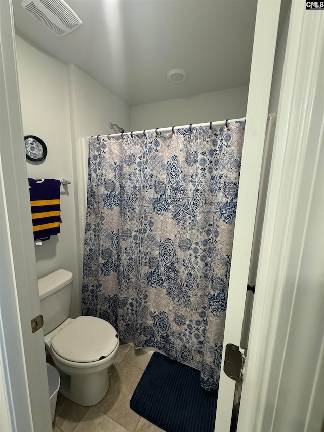 bathroom with tile patterned flooring, a shower with shower curtain, and toilet