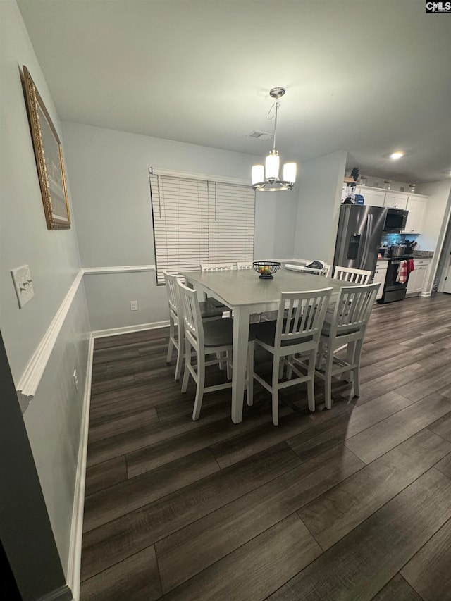 dining room featuring a chandelier and dark hardwood / wood-style floors