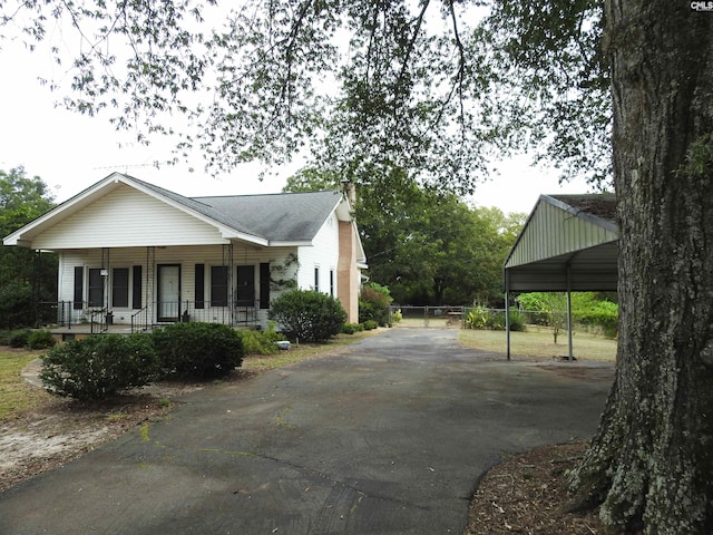 view of property exterior with covered porch and a carport