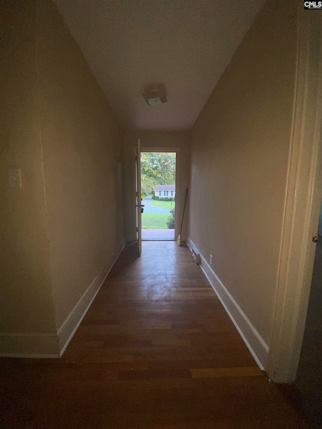 hall with vaulted ceiling and hardwood / wood-style flooring