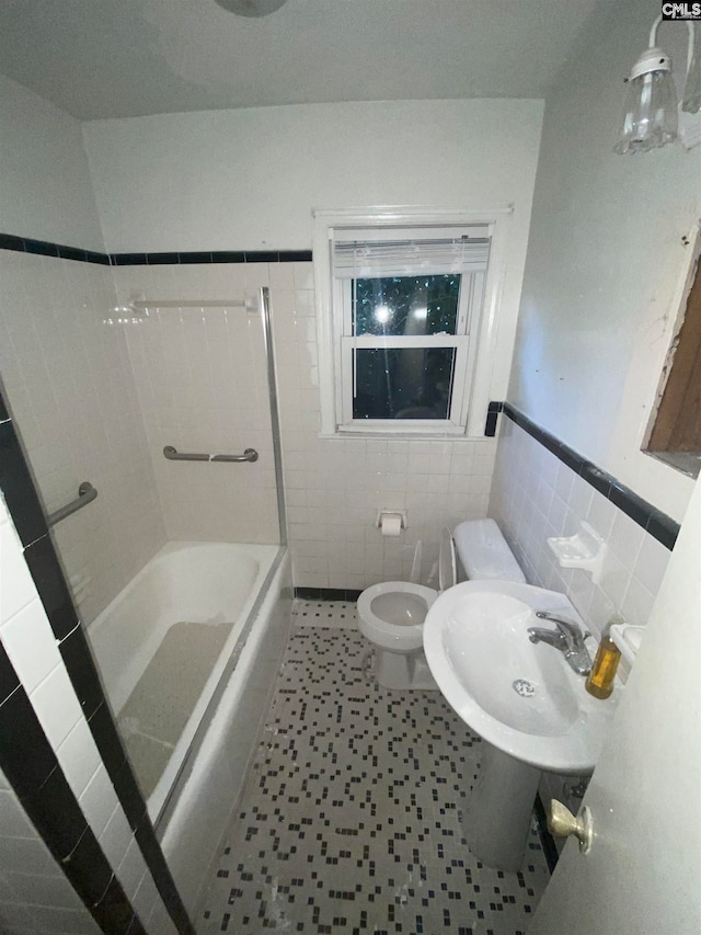 full bathroom featuring tub / shower combination, toilet, tile patterned floors, sink, and tile walls