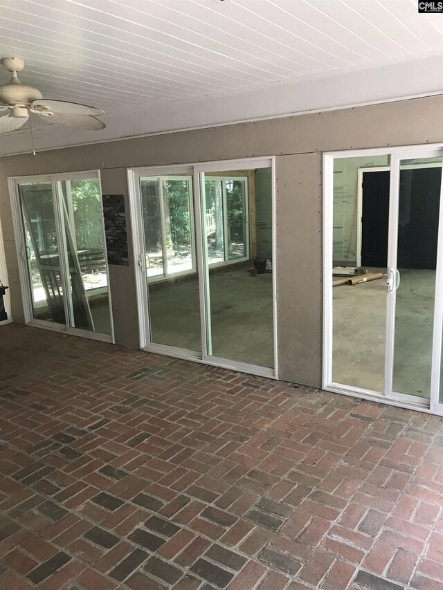 unfurnished sunroom featuring ceiling fan