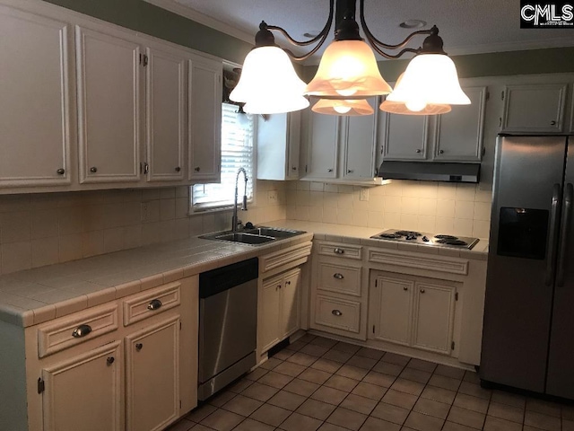 kitchen featuring stainless steel appliances, white cabinets, sink, hanging light fixtures, and tile countertops