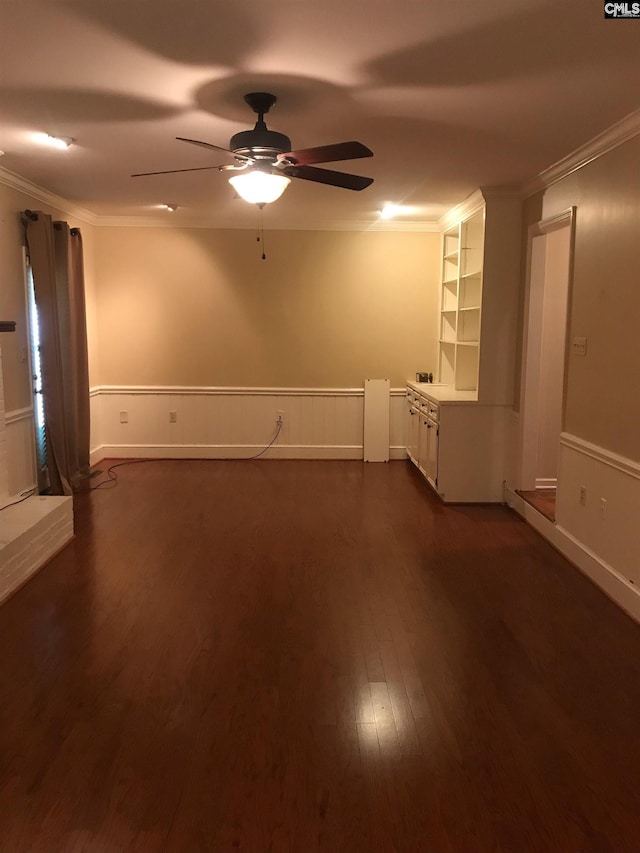 unfurnished room featuring dark wood-type flooring, built in features, ornamental molding, and ceiling fan