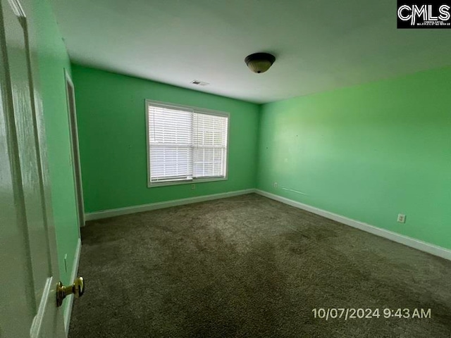 unfurnished room featuring dark colored carpet