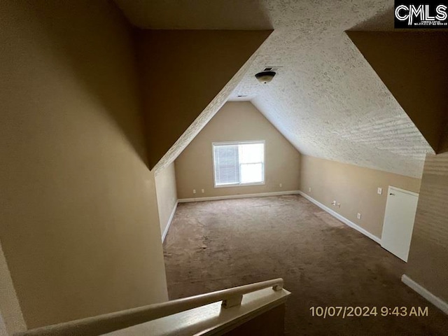 bonus room with carpet floors, vaulted ceiling, and a textured ceiling