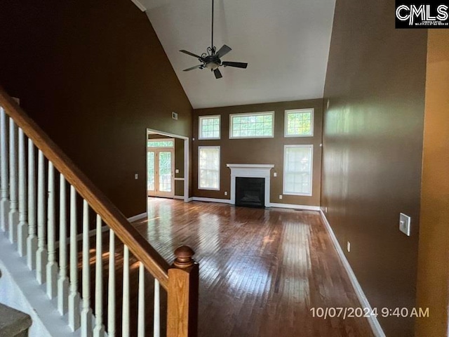 unfurnished living room with plenty of natural light, high vaulted ceiling, wood-type flooring, and ceiling fan