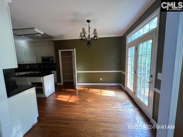 kitchen featuring hanging light fixtures, hardwood / wood-style floors, a healthy amount of sunlight, and white cabinetry