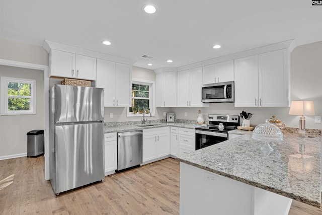 kitchen featuring light stone countertops, appliances with stainless steel finishes, sink, and white cabinetry