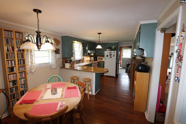 dining space with ornamental molding, sink, a chandelier, and dark hardwood / wood-style flooring