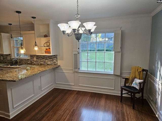 dining space featuring a notable chandelier, dark hardwood / wood-style floors, sink, and crown molding