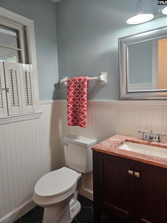 bathroom featuring vanity, tile patterned flooring, and toilet