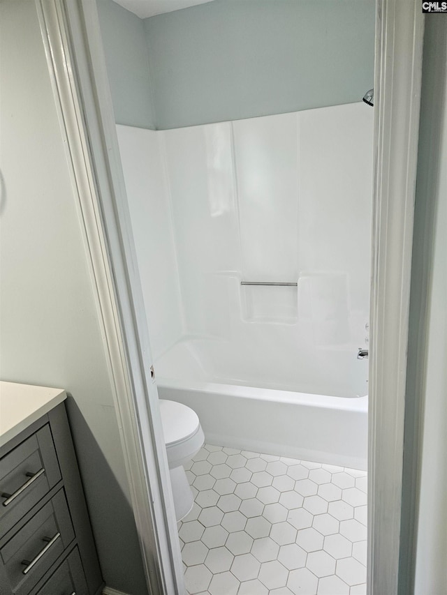 full bathroom featuring tile patterned flooring, vanity, washtub / shower combination, and toilet