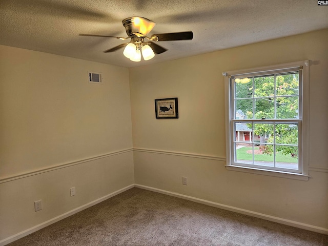 carpeted spare room with ceiling fan and a textured ceiling