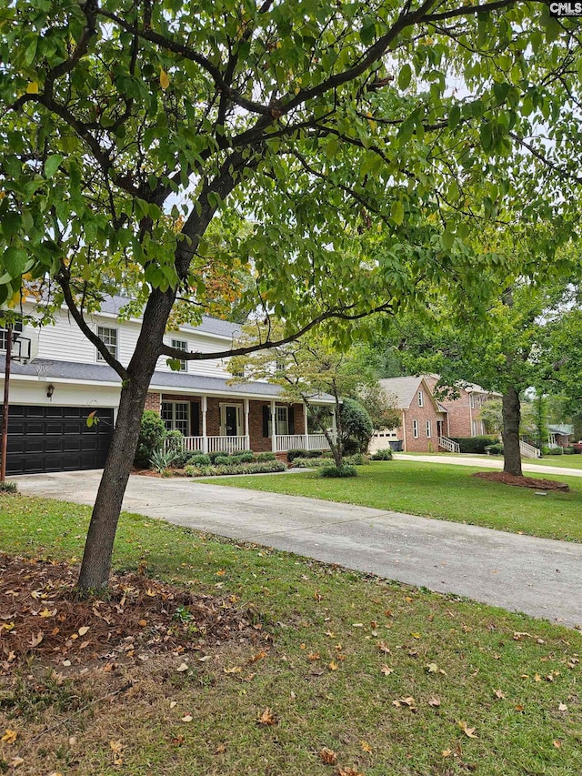 single story home featuring a garage, a front lawn, and covered porch