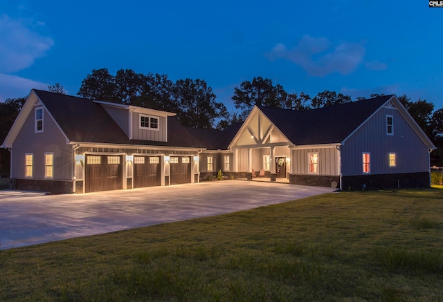 view of front of property with a garage and a lawn