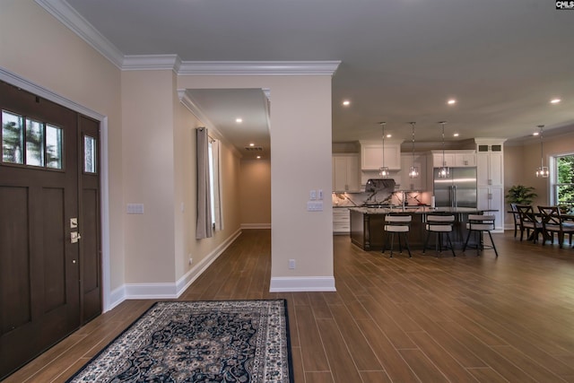 entrance foyer featuring dark wood-type flooring and ornamental molding