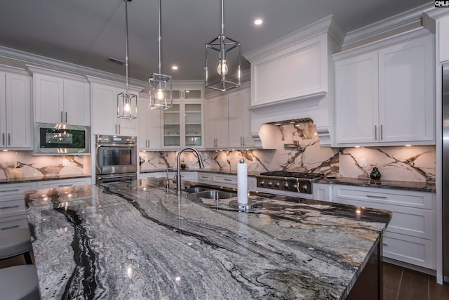 kitchen featuring hanging light fixtures, sink, backsplash, white cabinets, and appliances with stainless steel finishes