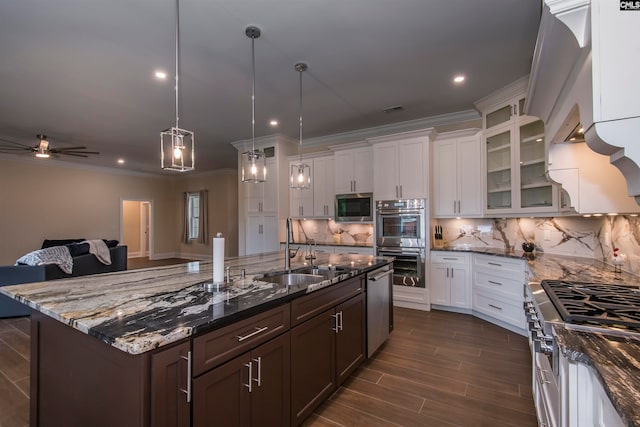 kitchen featuring stainless steel appliances, white cabinets, sink, pendant lighting, and backsplash