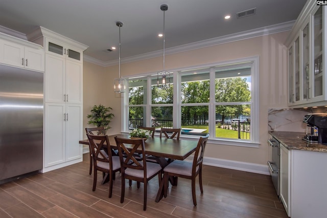 dining area with a notable chandelier, dark hardwood / wood-style floors, and crown molding