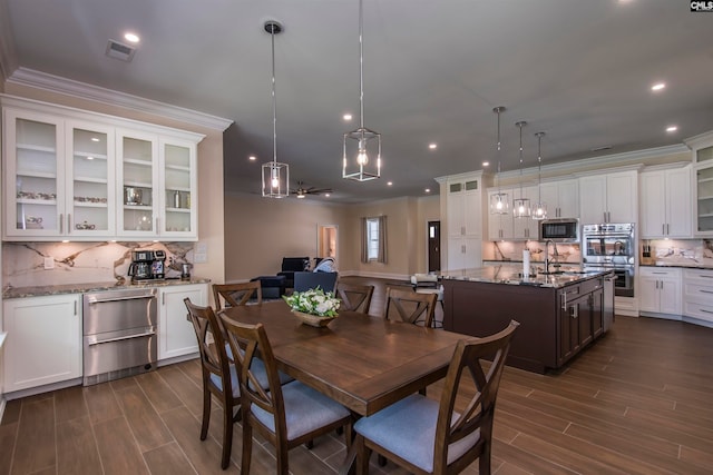 dining area with crown molding, dark hardwood / wood-style flooring, and sink