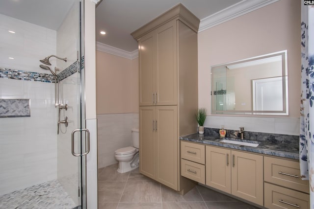 bathroom with vanity, tile walls, a shower with shower door, ornamental molding, and toilet