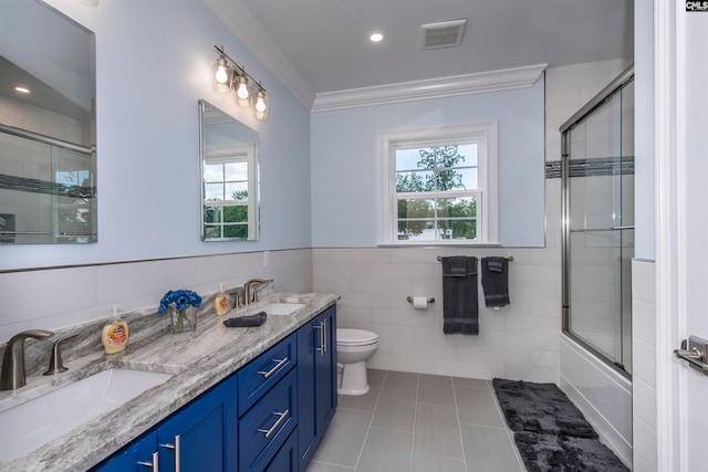 full bathroom with vanity, enclosed tub / shower combo, tile patterned floors, crown molding, and toilet