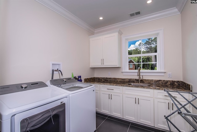 clothes washing area with washing machine and dryer, sink, ornamental molding, and cabinets