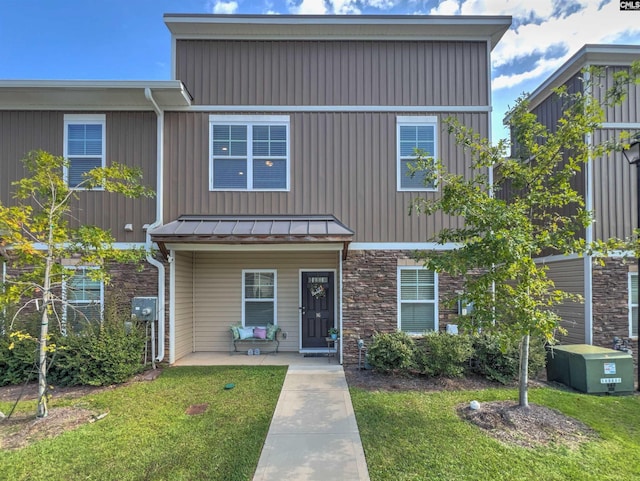 townhome / multi-family property featuring a front lawn and a patio