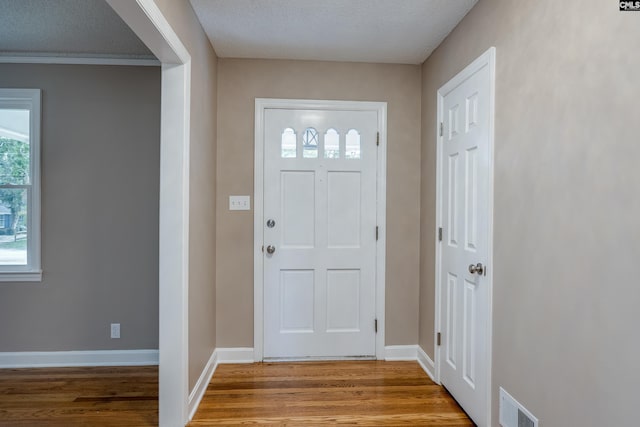 foyer entrance featuring light hardwood / wood-style floors and a textured ceiling