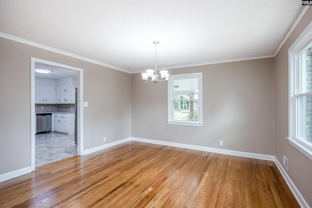 unfurnished room with a chandelier, light hardwood / wood-style floors, crown molding, and a wealth of natural light