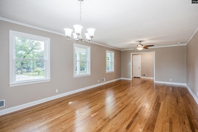 spare room with ceiling fan with notable chandelier, crown molding, a wealth of natural light, and wood-type flooring