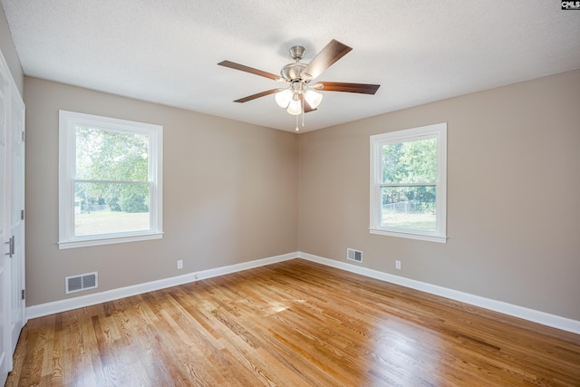 spare room featuring light hardwood / wood-style floors, a textured ceiling, and ceiling fan