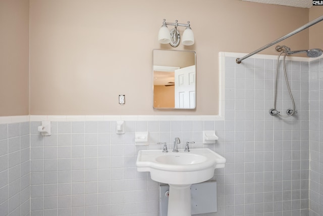 bathroom with tiled shower and tile walls