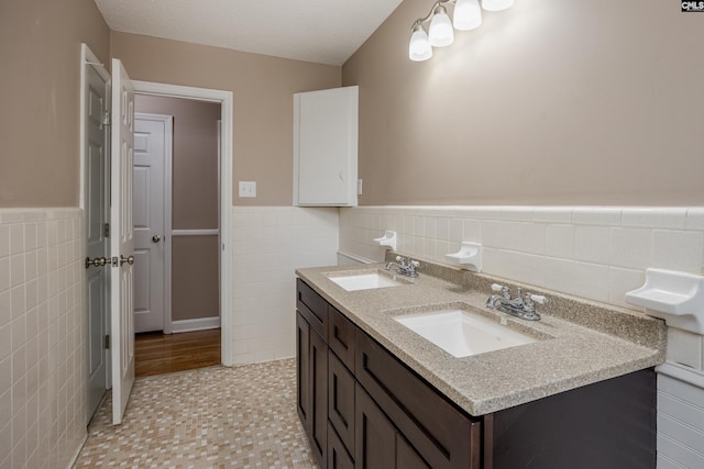 bathroom with vanity, tile walls, and a textured ceiling