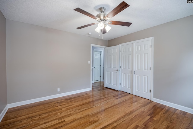 unfurnished bedroom with a closet, light hardwood / wood-style floors, a textured ceiling, and ceiling fan