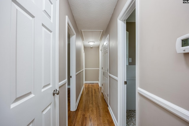 corridor featuring hardwood / wood-style flooring and a textured ceiling