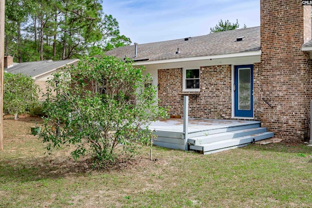 rear view of property with a wooden deck and a yard