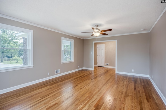 spare room with ceiling fan, light wood-type flooring, plenty of natural light, and crown molding