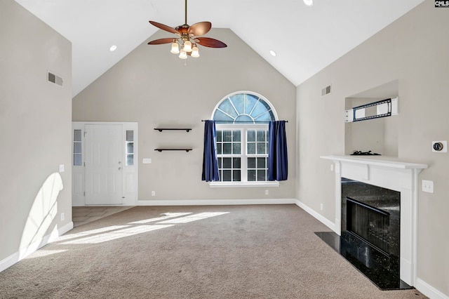 unfurnished living room featuring high vaulted ceiling, carpet flooring, a premium fireplace, and ceiling fan