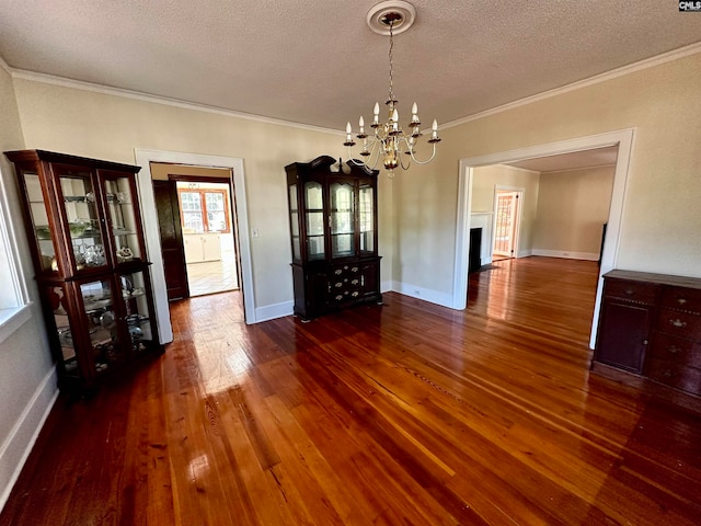 unfurnished dining area with ornamental molding, an inviting chandelier, dark hardwood / wood-style floors, and a textured ceiling