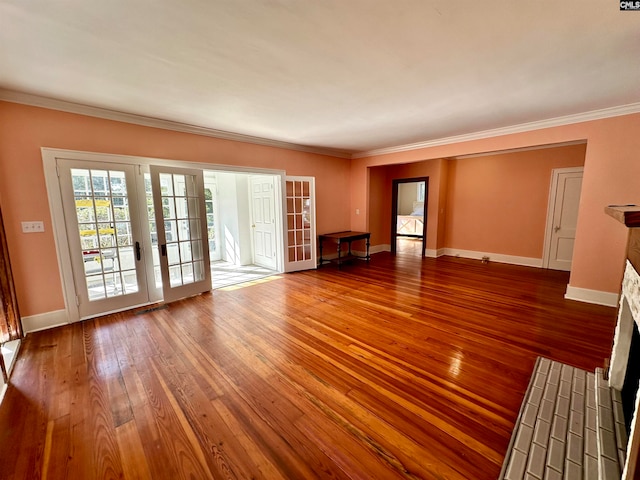 unfurnished living room featuring wood-type flooring, crown molding, and french doors