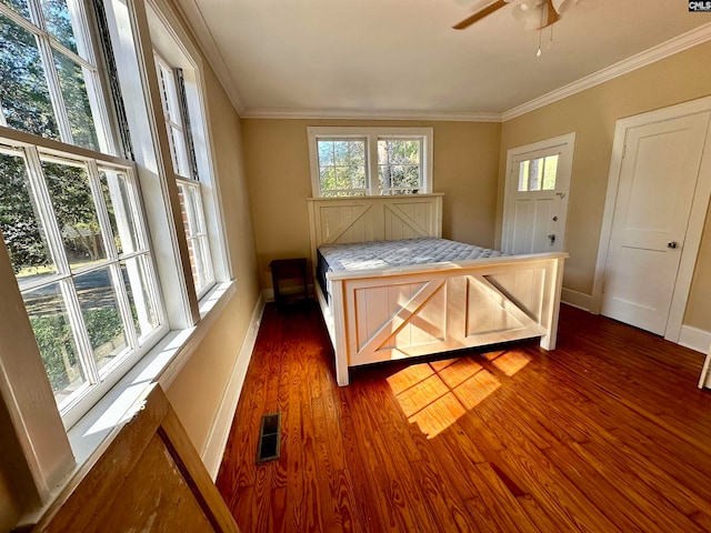 bedroom with crown molding, ceiling fan, and dark hardwood / wood-style flooring