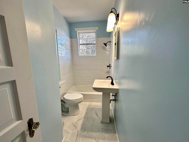 bathroom with tiled shower / bath, toilet, and tile patterned floors