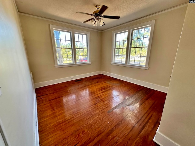 empty room featuring plenty of natural light, ceiling fan, wood-type flooring, and a textured ceiling