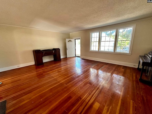 unfurnished living room with a textured ceiling and dark hardwood / wood-style floors