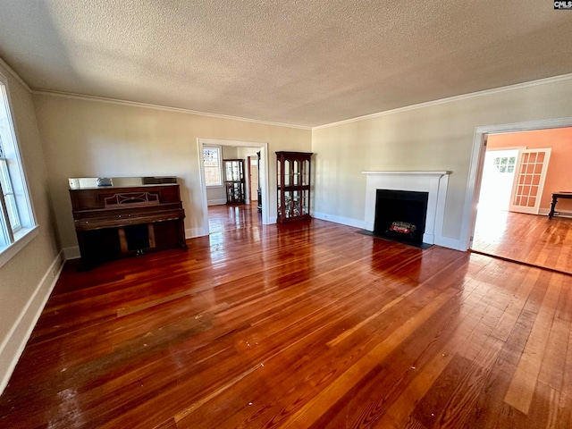 unfurnished living room with dark wood-type flooring, crown molding, and a textured ceiling