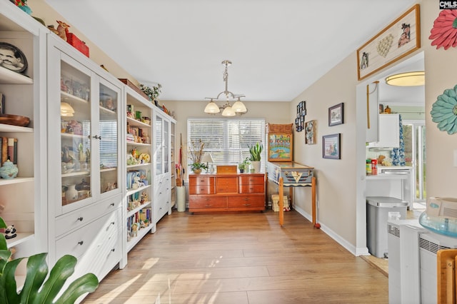 dining room featuring light wood-type flooring, a chandelier, and a healthy amount of sunlight