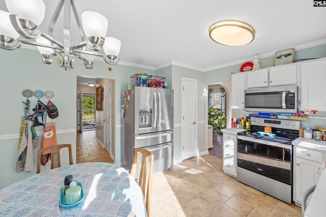 kitchen featuring white cabinets, ornamental molding, decorative light fixtures, a chandelier, and appliances with stainless steel finishes