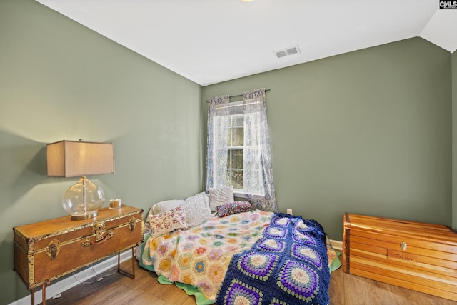 bedroom with lofted ceiling and light hardwood / wood-style floors